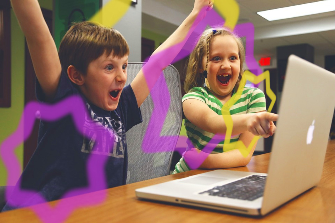 Children interacting excitedly with a laptop